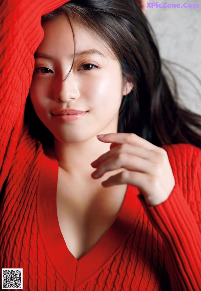 A woman in a red sweater is posing for a picture.