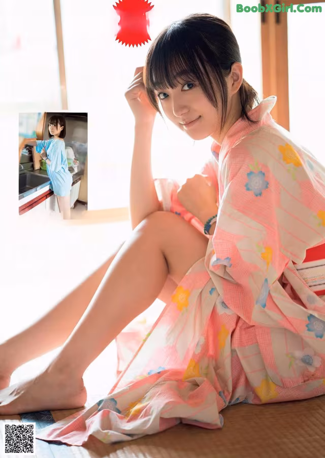 A woman in a pink kimono sitting on the floor.