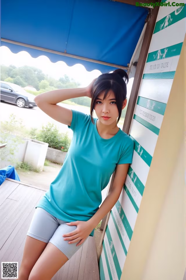 A woman in a green shirt and gray shorts posing for a picture.