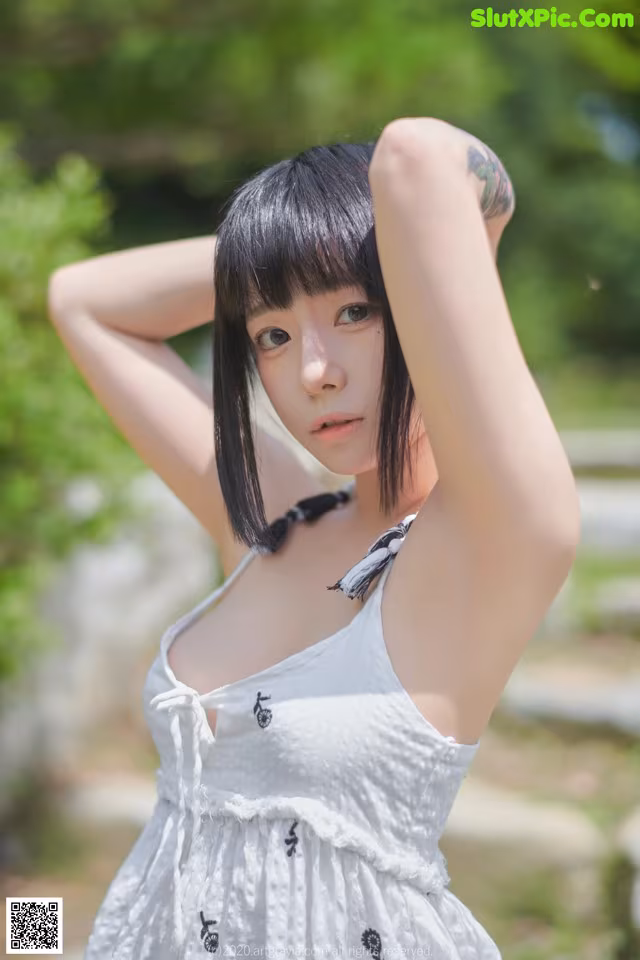 A woman in a white dress posing for a picture.