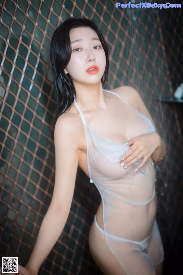 A woman in a white lingerie posing in the shower.