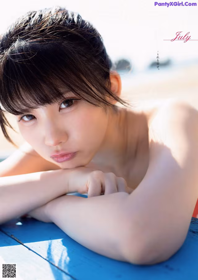 A young woman laying on top of a blue table.