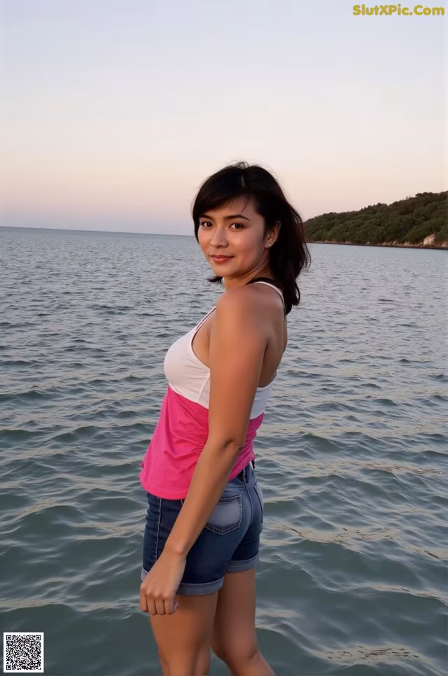 A woman standing in the water with her hands on her hips.