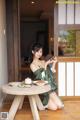 A woman sitting at a table with a bowl of food.