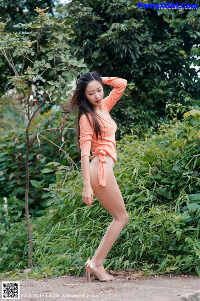 A woman in a pink shirt is posing for a picture.