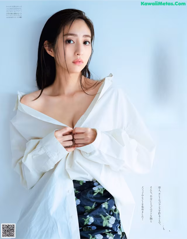 A woman in a white shirt is posing for a magazine.