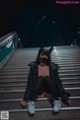 A woman wearing a mask sitting on a set of stairs.