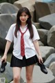 A woman in a school uniform is posing for a picture.