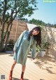 A woman standing on a wooden deck next to a tree.