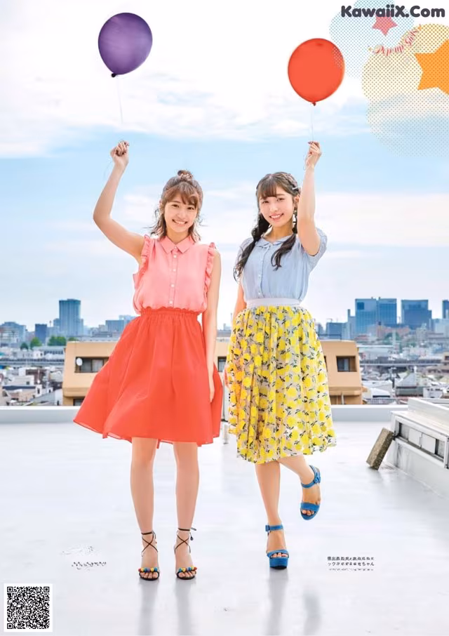 A couple of women standing next to each other holding balloons.